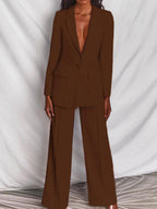 Costume marron élégant pour femme, veste à col en V profond, pantalon large, mode chic, tenue professionnelle, fond blanc drapé.