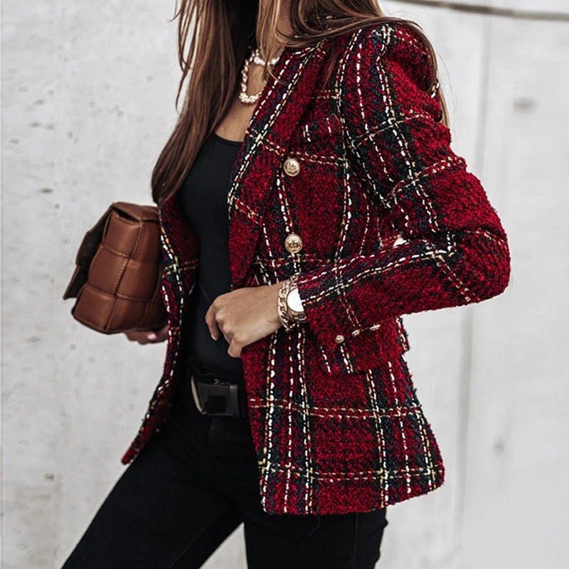 Femme portant une veste en tweed rouge à carreaux, boutons dorés, tenue élégante, sac marron, mode automne chic, style urbain sophistiqué.