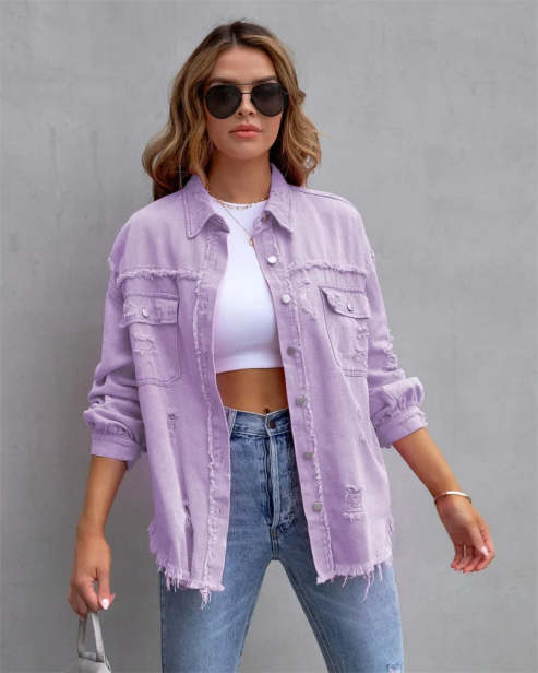 Femme portant une chemise en jean lavande, lunettes de soleil noires, t-shirt blanc court et jean bleu. Mode décontractée, tendance urbaine.