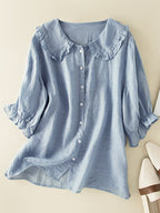 Chemisier bleu clair en lin avec col à volants et manches trois-quarts, boutons blancs, style décontracté et élégant pour femme.