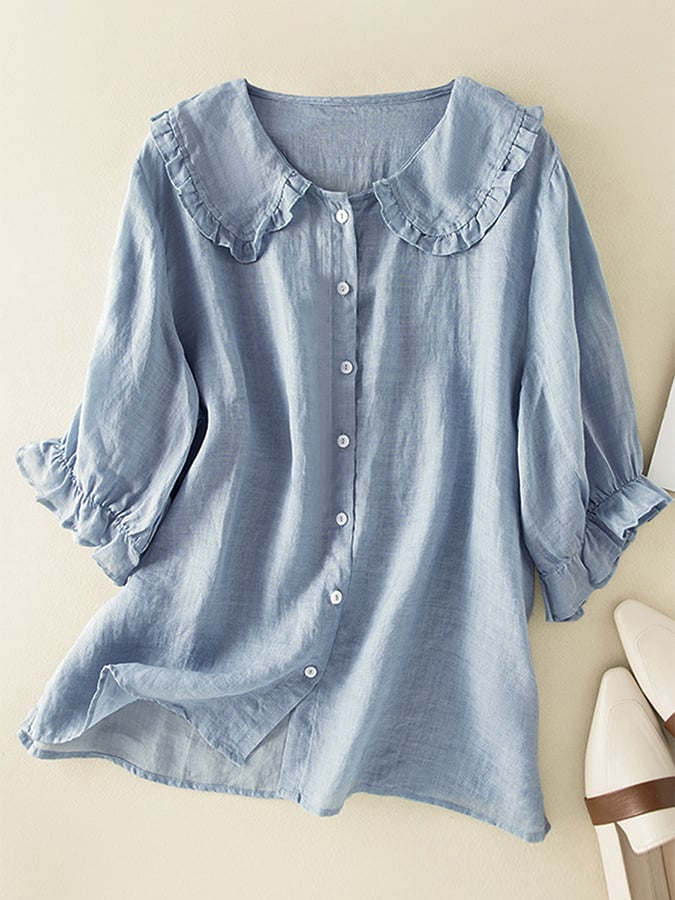 Chemisier bleu clair en lin avec col à volants et manches trois-quarts, boutons blancs, style décontracté et élégant pour femme.