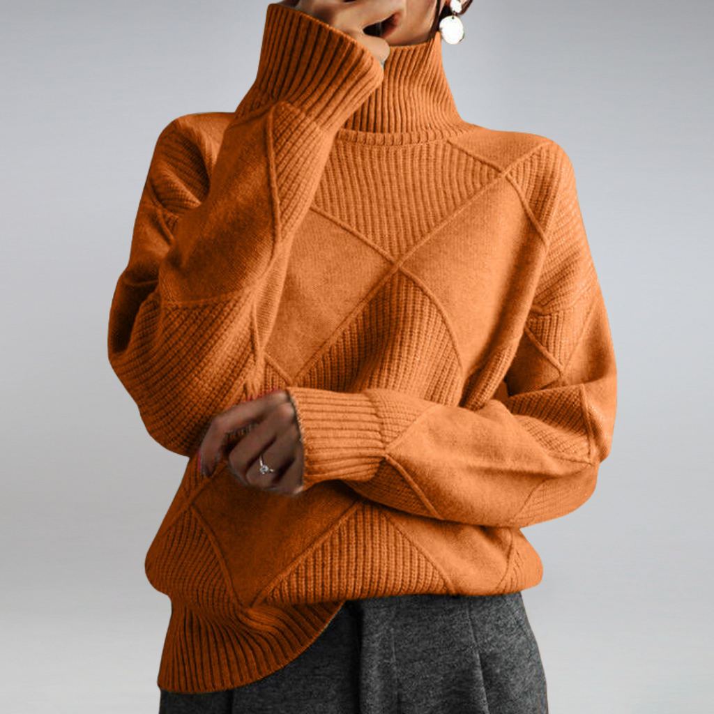 Pull-over en maille orange à col roulé, motif géométrique, manches longues, porté par une personne. Mode automne-hiver, style décontracté et élégant.