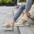 Femme portant des baskets compensées dorées, assise sur des marches en extérieur. Chaussures mode tendance, confortables et élégantes pour la marche.