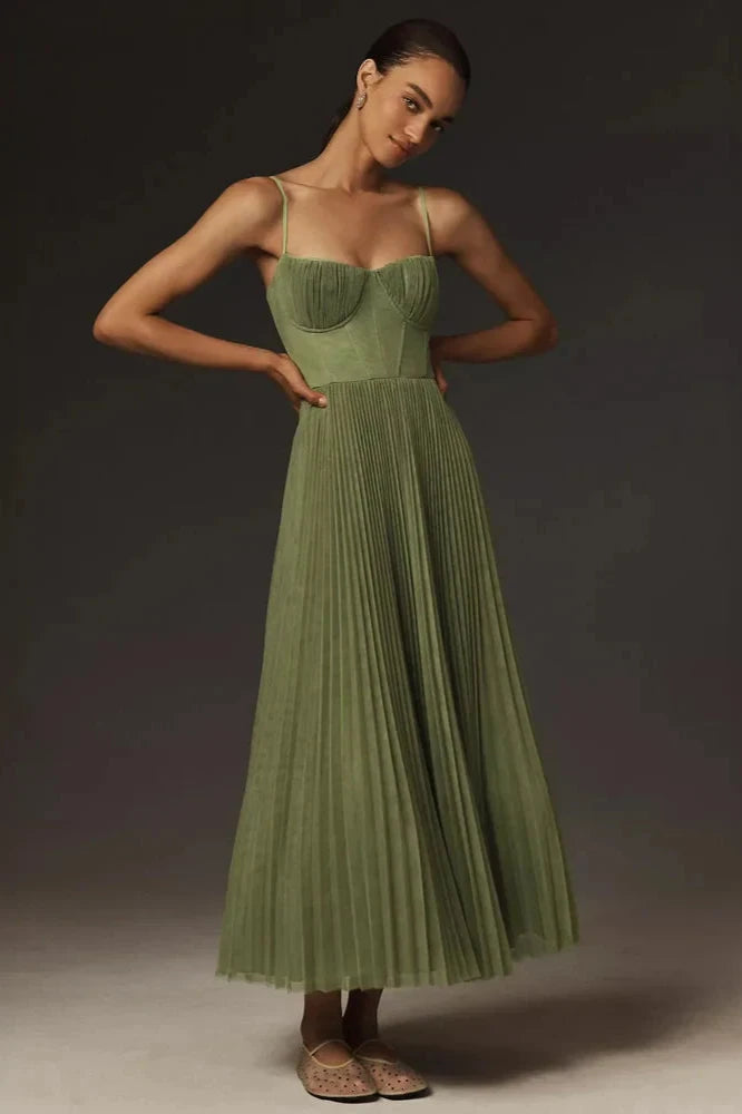 Robe longue plissée verte élégante portée par une femme, bretelles fines, style chic et moderne, idéale pour soirées ou événements spéciaux.
