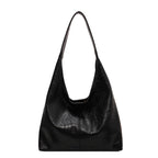 Sac à main noir en cuir vegan, design minimaliste, bandoulière longue, mode éthique, accessoire tendance pour femme, style élégant et moderne.