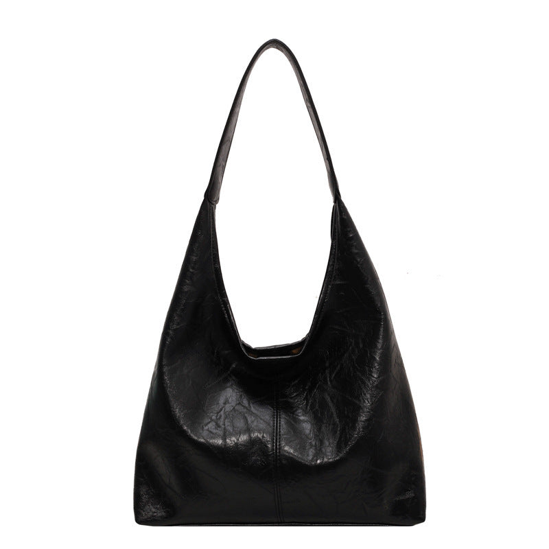Sac à main noir en cuir vegan, design minimaliste, bandoulière longue, mode éthique, accessoire tendance pour femme, style élégant et moderne.