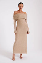 Robe longue beige à épaules dénudées, manches longues, portée par une femme. Mode élégante, tendance, tenue de soirée chic.