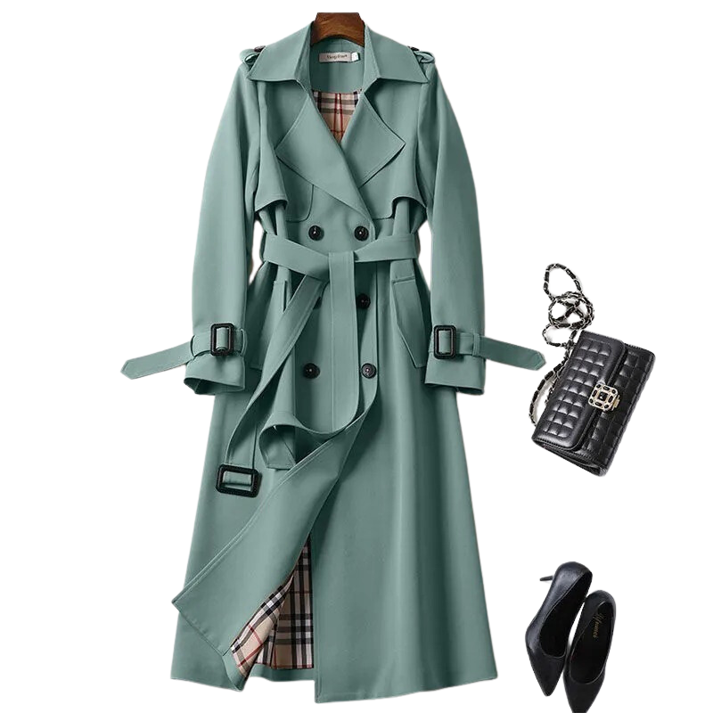 Manteau trench vert élégant avec doublure à carreaux, ceinture assortie, sac à main noir en cuir et escarpins noirs. Mode automne chic.