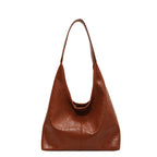 Sac à main en cuir marron, design minimaliste, bandoulière large, style élégant et moderne, accessoire de mode pour femme.