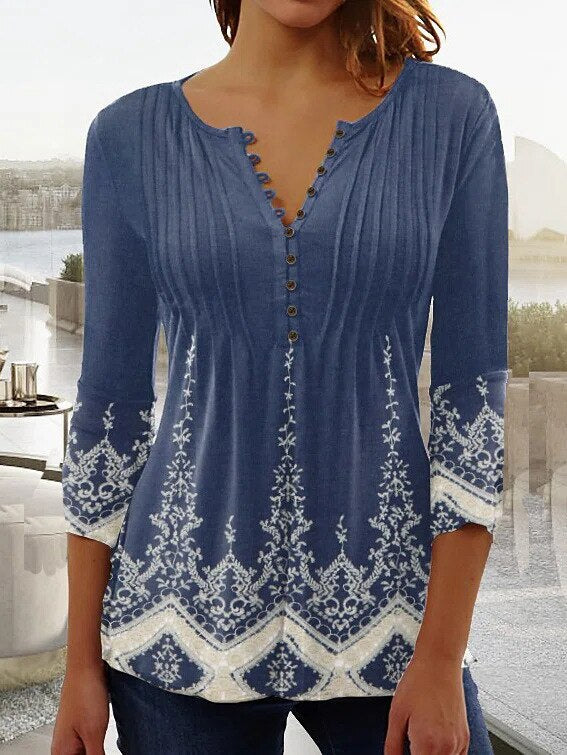 Blouse bleue à manches longues pour femme avec motifs floraux blancs, col en V boutonné, style décontracté, idéale pour mode automne-hiver.