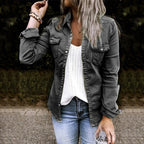 Femme en chemise en jean gris, t-shirt blanc et jeans bleus, tenant une boisson. Mode décontractée, style urbain, extérieur.