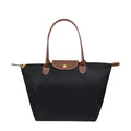Sac à main noir élégant avec poignées en cuir marron, design classique et minimaliste, idéal pour la mode féminine et le quotidien.