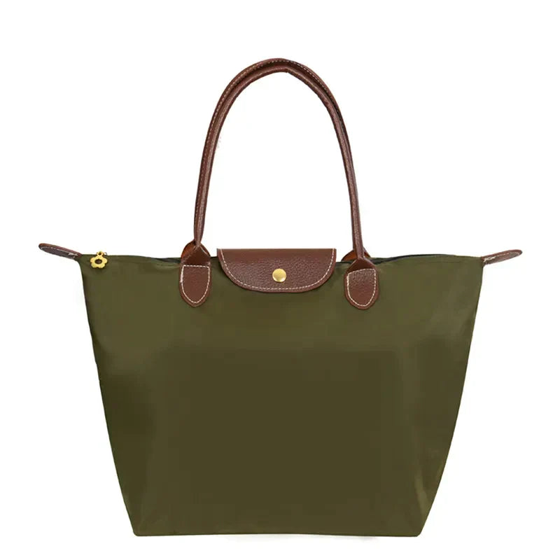 Sac à main en toile vert olive avec poignées et rabat en cuir marron, design élégant et pratique, idéal pour la mode féminine et le quotidien.