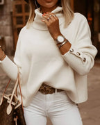 Femme portant un pull blanc à col roulé avec boutons, montre élégante et sac à main de luxe. Mode automne chic, style décontracté et tendance.