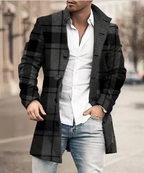 Homme portant un manteau à carreaux noir et gris, chemise blanche et jean décontracté, marchant en ville. Mode masculine élégante et moderne.