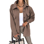 Femme portant une surchemise marron tendance, chemise blanche, pantalon beige, collier doré, tenant un sac à carreaux. Mode automne chic.