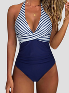 Maillot de bain une pièce bleu marine et blanc à rayures, décolleté plongeant, bretelles croisées, idéal pour plage et piscine.