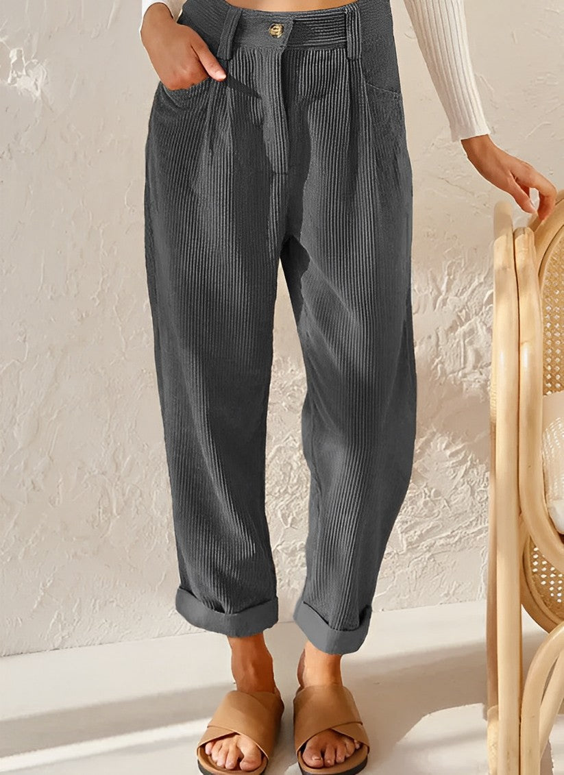 Pantalon ample gris en velours côtelé, style décontracté, avec poches avant. Parfait pour une tenue automnale chic et confortable.
