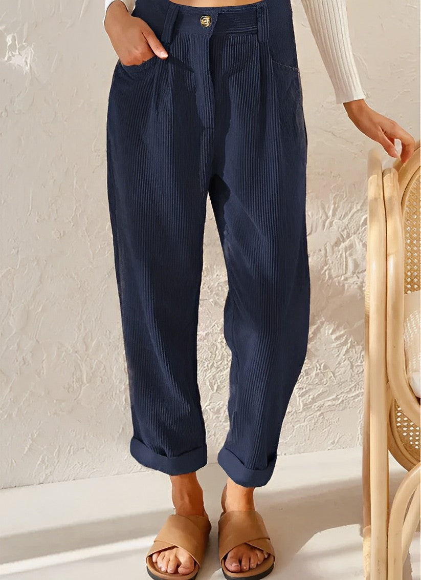 Pantalon bleu marine en velours côtelé, coupe ample, taille haute, avec ourlets retroussés. Mode décontractée, tendance automne-hiver.