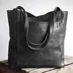 Sac cabas en cuir noir élégant sur une table en bois, design moderne et minimaliste, parfait pour le shopping ou le bureau. Accessoire mode tendance.