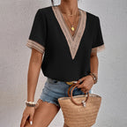 Femme portant un t-shirt noir à col en V avec dentelle, short en jean, tenant un sac en osier. Mode estivale, tenue décontractée chic.