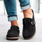 Chaussures mocassins noires en daim avec boucle, portées avec un jean retroussé. Style décontracté, tendance, confort, mode urbaine.