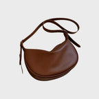 Sac à main en cuir marron, design demi-lune, bandoulière ajustable. Accessoire mode élégant et tendance pour femme.