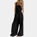 Combinaison noire femme, style décontracté, sans manches, jambes larges, boutons latéraux, mode tendance, tenue estivale élégante.
