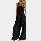 Combinaison noire femme, style décontracté, sans manches, jambes larges, boutons latéraux, mode tendance, tenue estivale élégante.