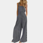 Combinaison femme ample en lin gris, sans manches, avec boutons latéraux, poches, et coupe décontractée. Mode estivale élégante et confortable.