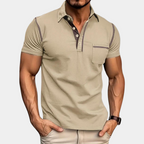 Homme musclé portant un polo beige ajusté avec poche poitrine, manches courtes, col boutonné, style décontracté. Mode masculine élégante.