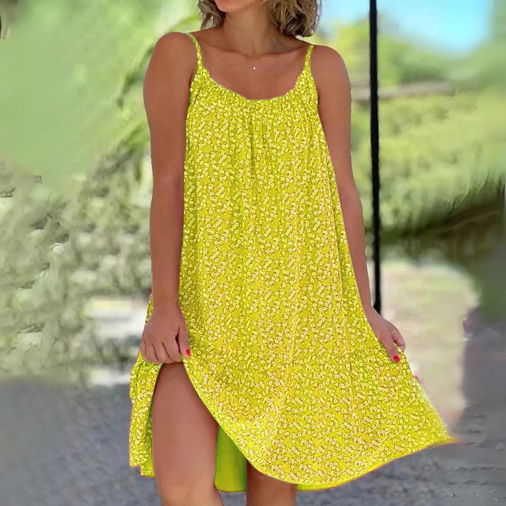 Robe d'été jaune à motifs floraux, sans manches, avec fente latérale, portée par une femme en extérieur. Mode féminine estivale tendance.