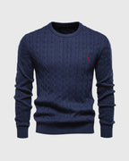 Pull bleu marine en maille torsadée, col rond, avec logo rouge brodé. Mode homme élégante, style classique, parfait pour l'automne-hiver.