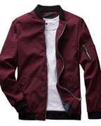 Veste bomber bordeaux pour homme avec col noir, fermeture éclair argentée, poche zippée sur la manche, portée sur un t-shirt blanc.