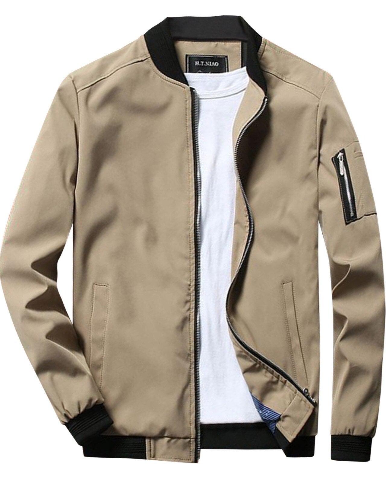 Veste bomber beige pour homme avec col noir, fermeture éclair, poche zippée sur la manche gauche, portée sur un t-shirt blanc. Mode masculine tendance.