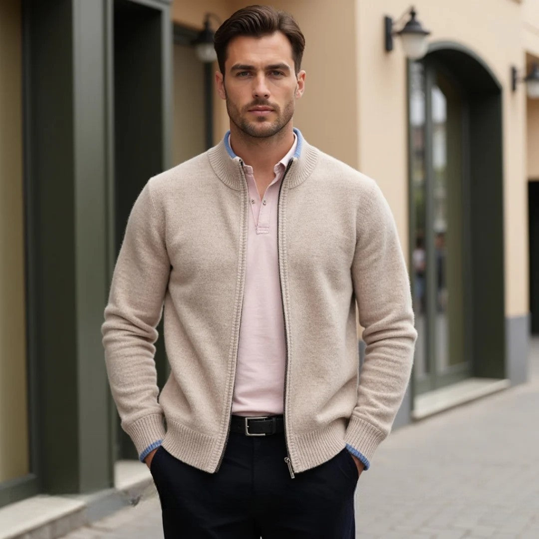Homme portant un cardigan beige et un polo rose, debout dans une rue commerçante. Mode masculine élégante, tenue décontractée chic.