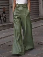 Pantalon large en cuir vert porté par une personne, style urbain chic, devant un mur de graffitis. Mode tendance, look moderne et élégant.