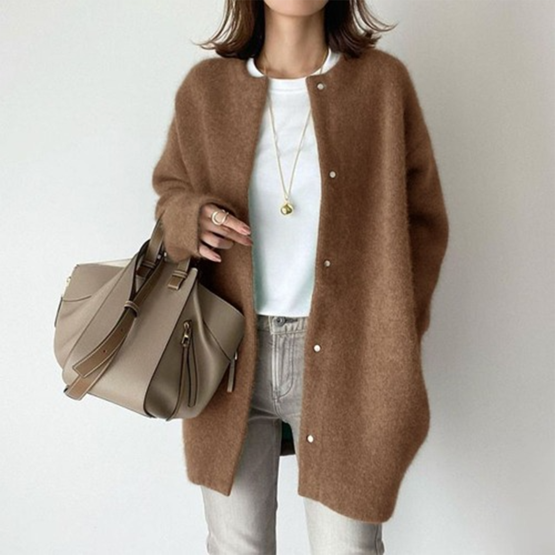 Femme portant un manteau en laine marron, sac à main beige, collier doré, tenue chic et décontractée, mode automne-hiver tendance.