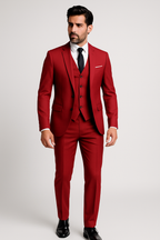 Homme en costume rouge élégant, cravate noire, chemise blanche, posant debout. Mode masculine, style formel, tendance vestimentaire.