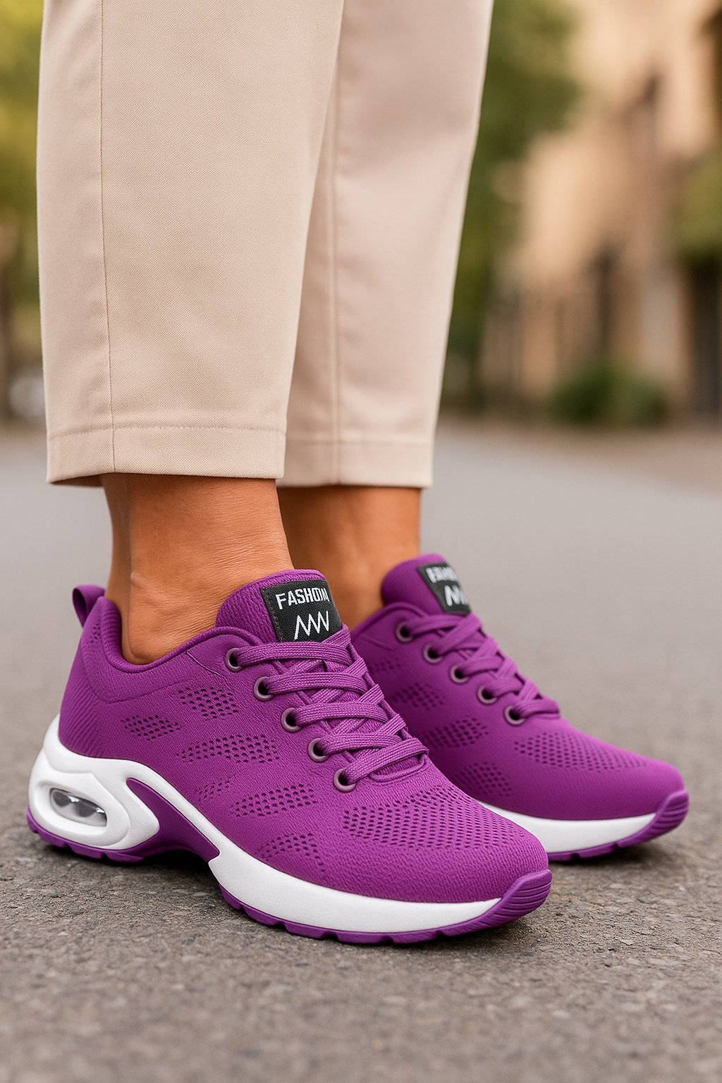 Chaussures de sport violettes pour femme sur trottoir, design moderne avec semelle blanche, idéales pour la marche et le fitness urbain.
