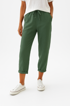 Pantalon vert femme, coupe décontractée, taille élastique avec cordon, ourlets retroussés, porté avec des baskets blanches et un t-shirt blanc.