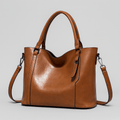 Sac à main en cuir marron élégant avec bandoulière amovible, design moderne et minimaliste, idéal pour la mode féminine et les accessoires tendance.