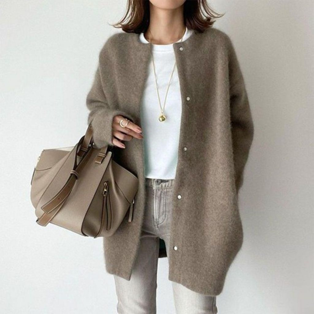 Femme portant un manteau en laine marron, t-shirt blanc, jean beige, avec un sac à main taupe. Mode automne-hiver, style décontracté chic.