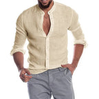 Homme portant une chemise en lin beige à manches longues, col mao, avec un pantalon gris. Mode masculine élégante et décontractée.
