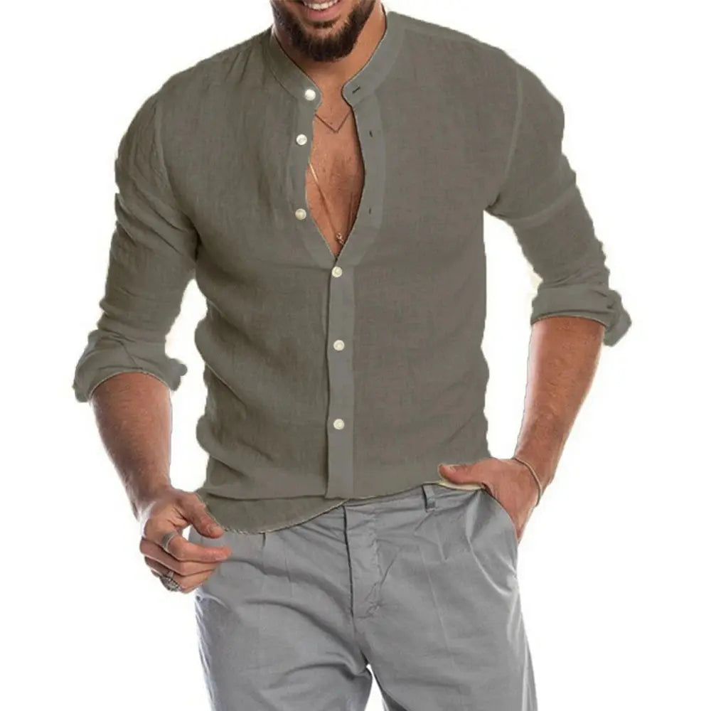 Homme portant une chemise en lin gris à manches longues, col mao, boutons blancs, associée à un pantalon gris clair. Mode masculine élégante.