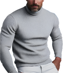 Homme portant un pull col roulé gris texturé, manches longues, style décontracté, mode masculine automne-hiver, sur fond blanc.