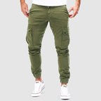 Pantalon cargo vert pour homme, style décontracté, poches latérales, coupe ajustée, idéal pour mode urbaine, porté avec baskets blanches.