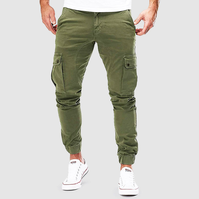 Pantalon cargo vert pour homme, style décontracté, poches latérales, coupe ajustée, idéal pour mode urbaine, porté avec baskets blanches.