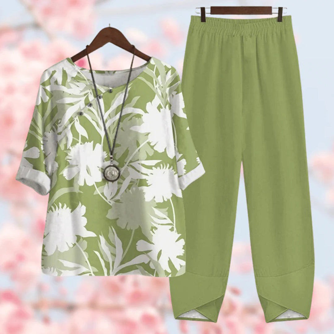 Tenue décontractée femme : ensemble vert avec haut à motifs floraux blancs et pantalon uni. Mode printemps-été, style chic et confortable.
