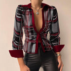 Femme portant une chemise à carreaux rouge et noir avec col ouvert, manches trois-quarts, associée à un pantalon en cuir noir. Mode élégante et tendance.